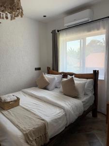 a bedroom with two twin beds with a window at City Retreat Arusha in Arusha