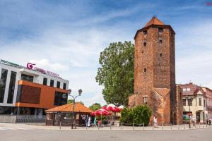 a tall brick tower sitting next to a building at Apartament Mostowa in Brodnica