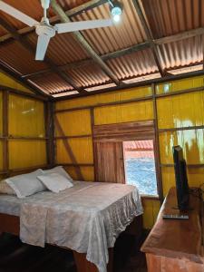 a room with a bed and a television in it at Parque Indigo Nature Lodge, Rincón de la Vieja in Liberia