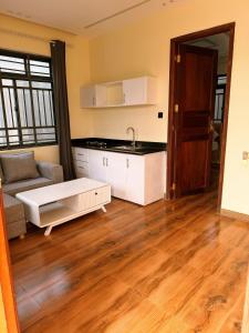a kitchen and living room with a couch and a table at Nungwicozy stay in Kinyasini