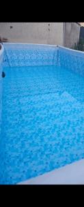 a blue swimming pool with blue tiles on it at Joli cocon familial in Neuilly-Saint-Front