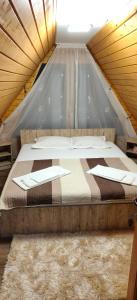 a bed in a tent in a room at Cabana A frame Nămăiești in Nămăeşti