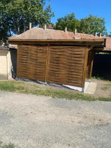 a large wooden garage with a roof on top of it at Andalics apartment in Kaposvár