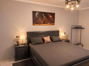 a bedroom with a bed and a painting on the wall at Pyramids View Rooftop Apartment in Ghaţāţī