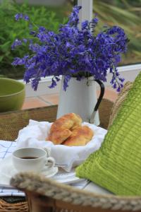 a table with a vase with purple flowers and croissants at Ty Llwyd in Treffynnon 