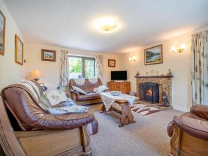 a living room with leather furniture and a fireplace at 3 Bed in Glengarrff oc-i089 in Glengarriff
