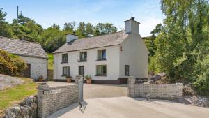 a large white house with a fence in front of it at 3 Bed in Glengarrff oc-i089 in Glengarriff