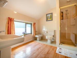 a bathroom with a tub and a toilet and a sink at 3 Bed in Glengarrff oc-i089 in Glengarriff +15 photos