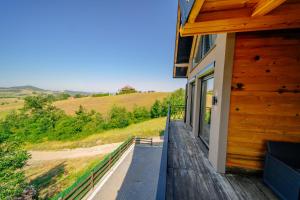 a porch of a house with a view of a field at LUX PINE house in Zlatibor