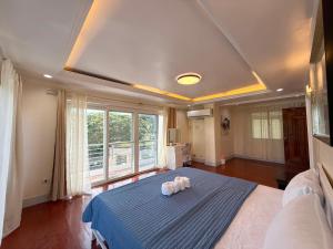 a bedroom with a large bed with a blue blanket at Dolores Cabin & Breakfast in Mactan