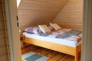 a bedroom with a bed in a wooden room at Domki Pod Lasem Lubkowo in Lubkowo