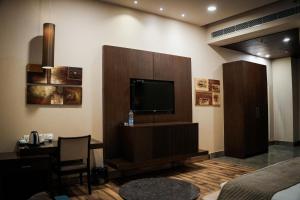 a living room with a flat screen tv and a table at Silver Palm Hotel & Resorts in Malaut