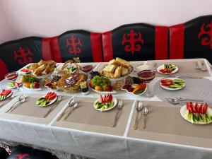a table with many plates of food on it at ERLAN Guest House in Jangy-Talap