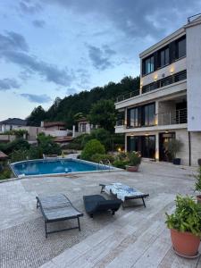 a house with a swimming pool and two benches at The Shefers Residence in Rogachevo