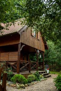 a log cabin with a porch and a window at Domki Pod Lasem Lubkowo in Lubkowo