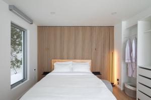 a bedroom with a large white bed and a window at VILLA-29 Spa, Sauna, Sunset & Waterfront View in Sainte-Petronille +15 photos