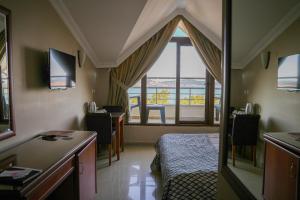 a room with a bed and a desk and a window at Casa Solada Cunda Resort & Spa in Ayvalık