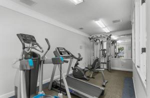 a gym with several tread machines in a room at Ocean Creek Resort in Myrtle Beach +27 photos