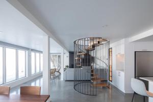 a spiral staircase in a home with a living room at VILLA-29 Spa, Sauna, Sunset & Waterfront View in Sainte-Petronille