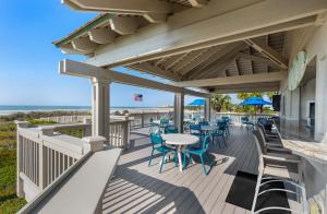 a deck with tables and chairs on the beach at Ocean Creek Resort in Myrtle Beach