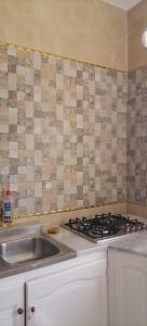 a kitchen with a sink and a stove at Maison Souad Guest House in Chott Meriem +7 photos