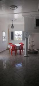 a room with a table and chairs and a fountain at Maison Souad Guest House in Chott Meriem