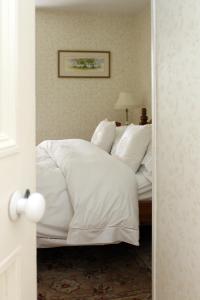 a bedroom with a bed with white sheets and pillows at Ty Llwyd in Treffynnon 