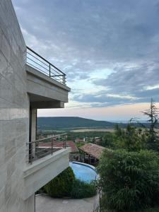 a house with a balcony and a swimming pool at The Shefers Residence in Rogachevo