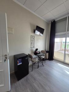 a waiting room with a table and chairs and a tv at Hotel La Oficina in San Miguel de Salinas