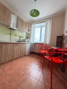a kitchen with red chairs and a table in it at Соборная Апартаменты in Kamianets-Podilskyi +6 photos