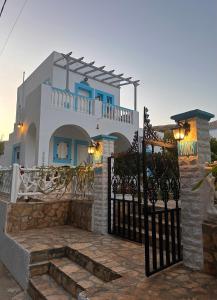 a blue and white house with a gate at EFFIE'S STUDIOS in Alinda