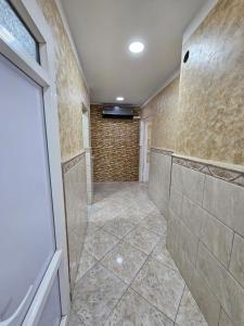 a bathroom with a walk in shower and a television at Appartement Luxe Alger in Birkhadem