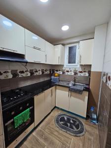 a kitchen with white cabinets and a sink and a stove at Appartement Luxe Alger in Birkhadem