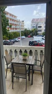 a table and chairs on a balcony with a view of a parking lot at Appartement une chambre cupecoy in Cupecoy