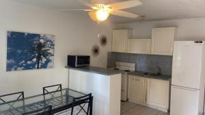 a kitchen with white cabinets and a white refrigerator at Appartement une chambre cupecoy in Cupecoy
