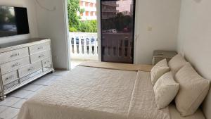 a bedroom with a bed and a tv and a window at Appartement une chambre cupecoy in Cupecoy
