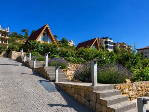 a stone retaining wall and stairs in front of a house at M Place in Shārūn