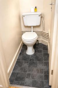 a bathroom with a toilet and a tile floor at Property Reality in London +28 photos