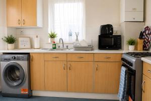 a kitchen with a sink and a washing machine at Property Reality in London