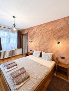 a bedroom with a large bed with a wooden wall at Krisiya's Apartment in Bansko