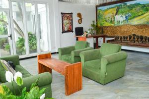 a living room with green chairs and a table at Namaya Nature Resort & Cafe in Kandy