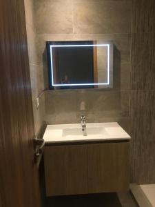 ein Badezimmer mit Waschbecken und Spiegel in der Unterkunft Taj 3 in Nouaceur