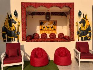 a room with red chairs and a mirror with a horse on the wall at Pyramids View Rooftop Apartment in Ghaţāţī