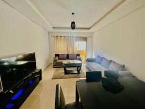 ein Wohnzimmer mit Sofa und Fernseher in der Unterkunft Taj 3 in Nouaceur
