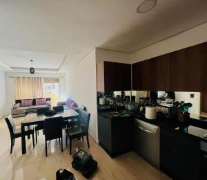 eine Küche und ein Esszimmer mit Tisch und Stühlen in der Unterkunft Taj 3 in Nouaceur