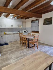 a large kitchen with a wooden table and chairs at Domek całoroczny Nad Stawem in Powidz