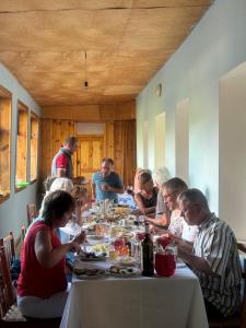 a group of people sitting around a table eating at Guesthouse Tetnuldi in Kʼolashi +25 photos