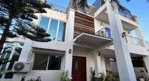 a white house with a red door at Dolores Cabin & Breakfast in Mactan +18 photos