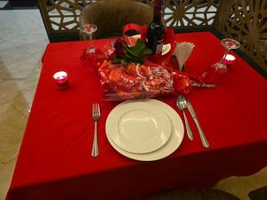 a red table with a white plate and fork and knife at The alder hotel and accommodation in Bungoma