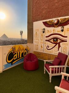 a room with an eye mural on the wall at Pyramids View Rooftop Apartment in Ghaţāţī +19 photos